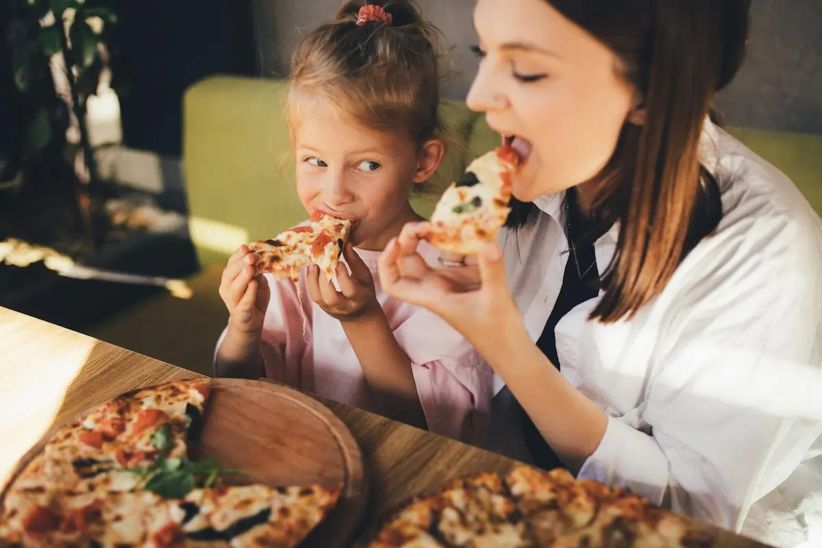 Kid eating Pizza With Mom