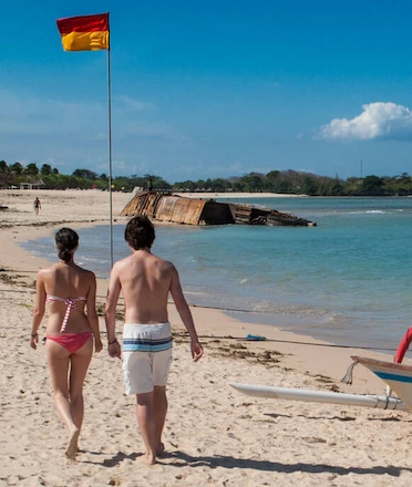 Couple walking on Mengiat Beach Nusa Dua's White Sandy Shore Couple walking on Mengiat Beach Nusa Dua's White Sandy Shore