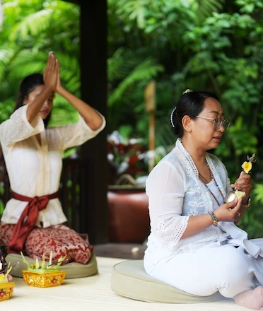 Tourist Praying With Female Mangku in Westin Ubud Tourist Praying With Female Mangku in Westin Ubud