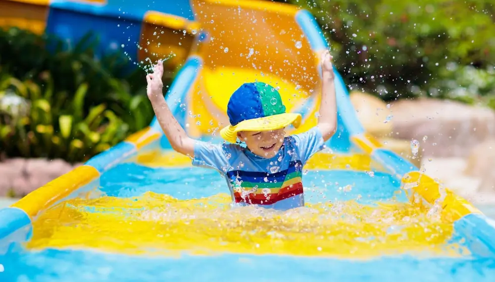  a little boy having fun at the waterslide pool