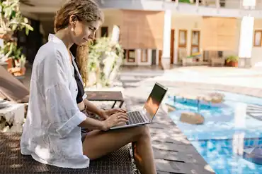 A woman digital nomad in bali working with a laptop