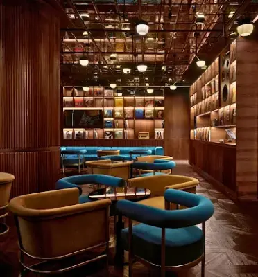 Vinyl listening bar interior with city views, record shelves, and lounge seating