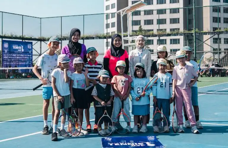 Children and organizers posing together on a tennis court during Aryaduta Tennis Day 2026 at Aryaduta Bandung.