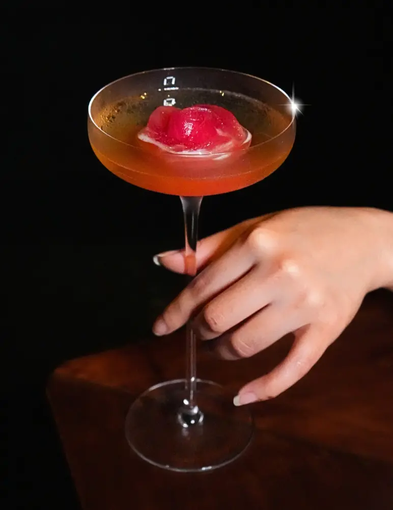Elegant cocktail in a coupe glass with red garnish