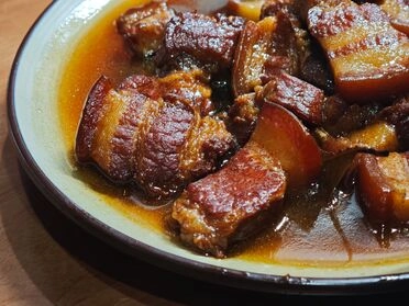 Braised pork belly pieces served in a rich savory sauce.