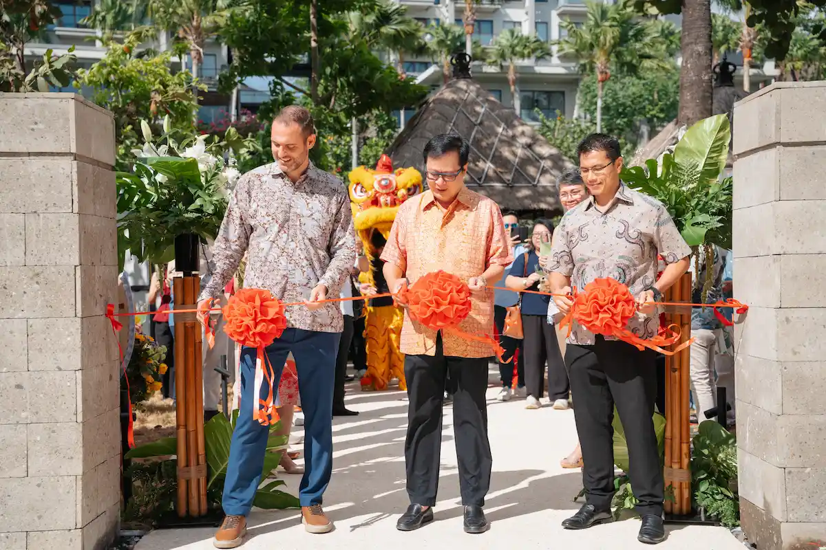 three people cutting a ribbon for new place