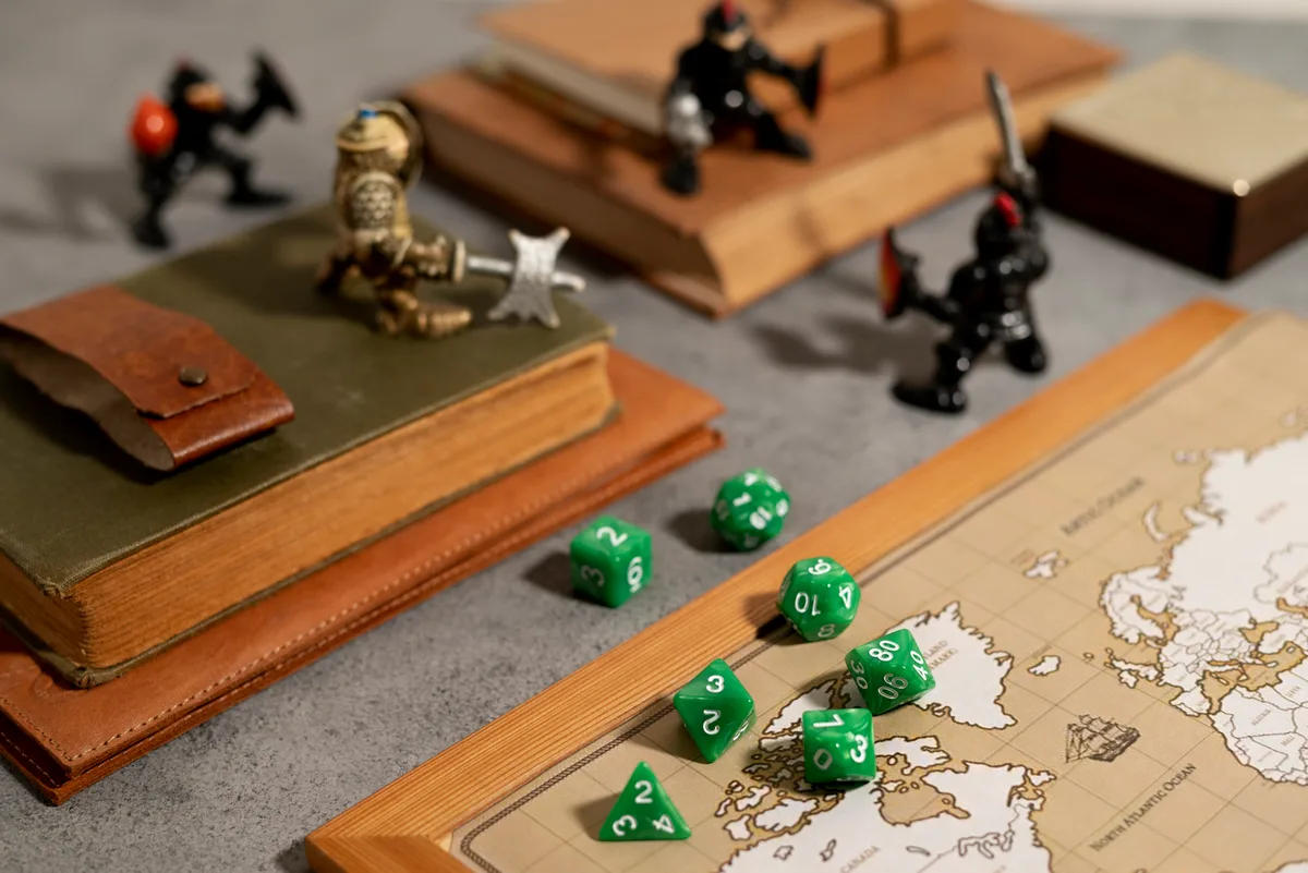 Fantasy-themed tabletop gaming setup with board game dice, miniature figurines, and a vintage map.