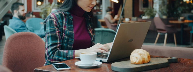 Woman_using_a_laptop_in_a_cozy_café