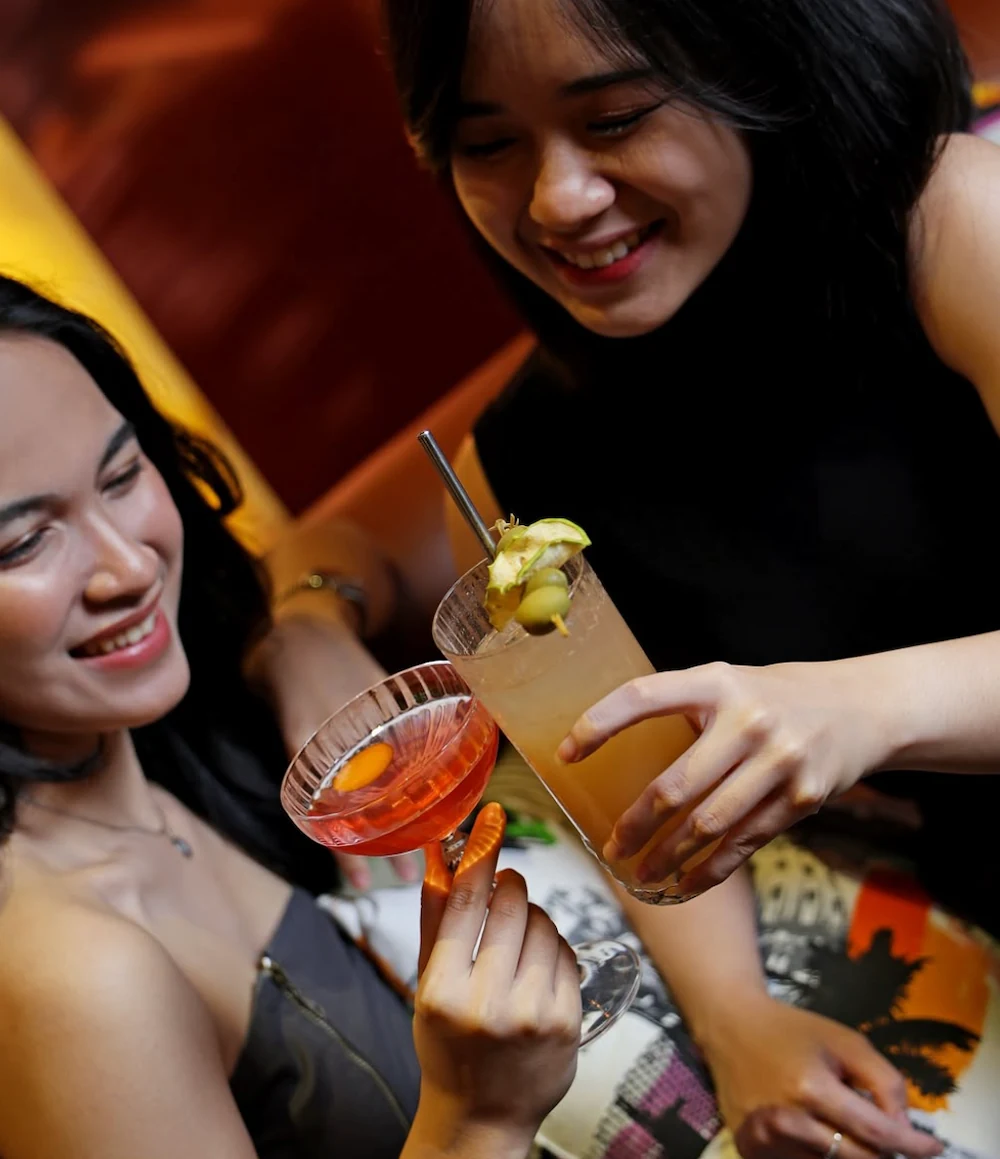 2 indonesian ladies holding cocktails